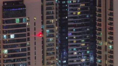 Modern kulelerin pek çok penceresinde ışık var. Geceleri parlayan pencereleri zaman ayarlı apartmanların dışında. Gökdelenlerin yukarıdan aydınlatmalı havadan görünüşü