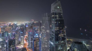 Panorama JBR bölgesini ve Dubai Marina 'yı JLT ile gösteriyor. Gökdelenler arasındaki otoyolda trafik vardı. Hava gece zaman çizelgesi. Aydınlatılmış modern kuleler ve inşaat alanı