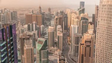 Gökdelenlerle çevrili Dubai Marina 'nın gökdelenleri sabah güneş doğarken kıyı şeridi boyunca panoramik görüntüsü. Yüzen yatlar ve tekneler. Dubai, BAE