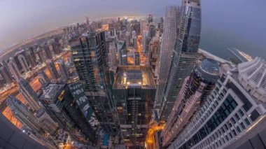 Dubai Marina 'nın gökdelenleri kıyı şeridi boyunca gece gündüz geçiş zamanları boyunca aydınlık gökdelenlerle çevrili. Gün doğumunda birçok yüksek kule ve cadde trafiği