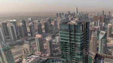 Panorama sabah Dubai Marina ve JLT 'yi JBR bölgesinde gösteriyor. Gökdelenler arasındaki otoyolda hava trafiği. Modern kuleler ve inşaat alanı. Limanda yüzen yatlar