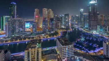 Dubai Marina 'da limanda park etmiş tekneleri ve yatları var ve tüm gece boyunca kanalın çevresindeki gökdelenleri aydınlatıyorlar. Arka planda JBR bölgesi kuleleri