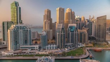 Gün batımında Dubai Marina 'da limana parkedilmiş birkaç tekne ve yatla ve kanalın çevresindeki gökdelenlerle. Arka planda JBR bölgesi kuleleri