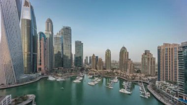 Dubai marinası en uzun gökdelenler ve yatlar liman havasında gün batımından sonra gece geçiş zamanı. Apartman binaları, oteller ve ofis blokları, modern yerleşim alanları