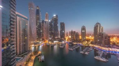 Dubai marinası en uzun gökdelenler ve yatlar liman havasında gece gündüz geçiş zamanları gün doğumundan önce. Apartman binaları, oteller ve ofis blokları, modern yerleşim alanları