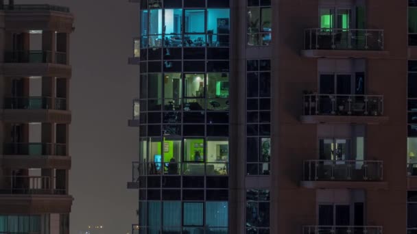 複数階建ての建物の空中のタイムラプスの窓の多色光のフラットナイトパノラマ 大都市のライトアップされた高層ビル — ストック動画