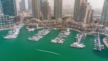 Tüm gün boyunca Dubai Marina 'da gölgeler hızla ilerlerken lüks tekne ve yatlar kenetlendi. Rıhtımda limana yakın park etmiş motorlu tekneler.