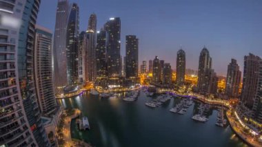 Dubai marinası en uzun gökdelenler ve yatlar liman havasında gece gündüz geçiş panoramik zaman dilimi güneş doğmadan önce. Apartman binaları, oteller ve ofis blokları, modern konutlar