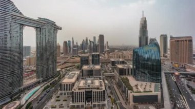 Fütürist Dubai Şehir Merkezi ve finans bölgesi panoramik gökyüzü gününden geceye geçiş zamanı. Birçok aydınlık kule ve gökdelenler caddelerde trafik var.