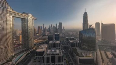 Güneşin doğuşundan batışına kadar bütün gün boyunca gelecekçi Dubai şehir merkezi ve finans bölgesi gökyüzü zaman çizelgesi. Gölgeleri hızlı hareket eden birçok kule ve gökdelenler