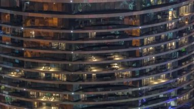 Gece vakti üst sınıf bir binanın pencerelerinin önünde oturuyorlardı. Gökdelende parlayan ışıklar. Balkonlarda sandalyeler