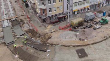 Beton yol yapımında çok sayıda işçi ve mikser makinesi, vinç, traktör zaman ayarlı çalışır. Tramvay raylarının yeniden inşası. Yukarıdan tüm gün boyunca gökyüzü görüntüsü