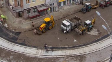 Asfalt kaldırım taşı, paten ve kamyon asfaltlama sırasında yol onarım alanında buldozer ile birlikte. Tramvay raylarının havadan görünüşü. Yol yapım ekipmanları. İnşaat işçileri