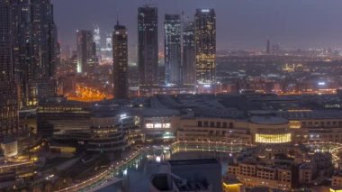 Dubai şehir merkezinde fıskiyeler ve modern fütüristik mimari gece gündüz geçiş zamanı. Finans bölgesi ve alışveriş merkezi olan gökdelenlere bak
