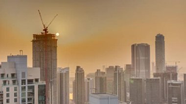 Büyük fütüristik şehir zaman diliminde havadan gün doğumu. Gökdelenleri, Dubai, Birleşik Arap Emirlikleri silueti olan iş sahası ve şehir merkezi bölgesi.