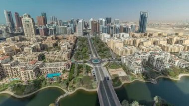 Barsha Heights bölgesindeki gökdelenler ve Greenens bölgesindeki alçak binalar. Dubai 'nin palmiyeler ve ağaçlarla kaplı panoramik silueti. Gölgeler hızlı hareket ediyor
