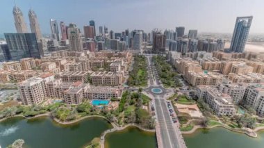Barsha Heights bölgesindeki gökdelenler ve tüm gün boyunca Greenens bölgesindeki alçak binalar. Dubai 'nin palmiyeler ve ağaçlarla kaplı panoramik silueti. Gölgeler hızlı hareket ediyor
