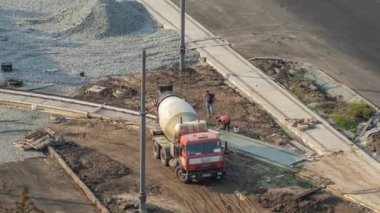 Betondaki karıştırma makinesi yol yapımında çalışıyor. Üniformalı zaman ayarlı birçok işçi var. Tramvay raylarının yeniden inşası. Havadan üst görünüm