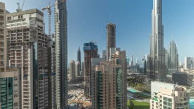 Panorama Dubai şehir merkezini gösteriyor. Hava zaman çizelgesinin etrafında en yüksek gökdelenler var. Yukarıdan gelen trafiğin yoğun olduğu yeni kulelerin ve yolların inşa edildiği yer