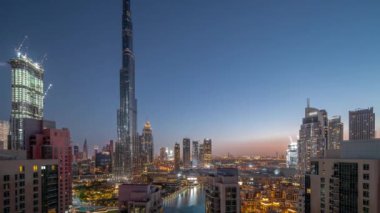 Dubai Şehir Merkezi panoramik şehir manzarası. Gece gündüz geçiş saatleri arasında en yüksek gökdelenler. Yukarıdan gelen trafiğin yoğun olduğu yeni kulelerin ve yolların inşa edildiği yer