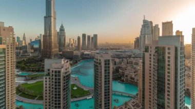 Gün doğarken Dubai şehir merkezi manzarası. Hava zaman aralığında en yüksek gökdelenler. Kulelerin arkasından güneş doğuyor. Yoğun yollar ve yukarıdaki trafik
