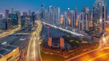 Business Bay hava sahasında modern kuleleri olan Bay Bulvarı gece gündüz panoramik geçiş zamanı, Dubai, BAE. Büyük otoparkın yakınındaki yolda trafiği olan gökdelenler.