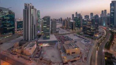 Dubai İş Körfezi gökdelenleri su kanalı havadan geceye geçiş panoramik zaman dilimi ile. Karmaşık kullanım geliştirme ile konut ve ofis kuleleri aynı ayak izini paylaşıyor