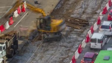 Endüstriyel kamyon yükleyicisi toprağı taşıyor ve eski demiryolu uyuyanlarını yol inşaatındaki bir çöp kamyonuna yüklüyor. Tramvay raylarının yeniden inşasının havadan görüntüsü