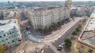 Ukrayna 'nın Kharkiv kentindeki tarihi binaların zaman çizelgesine sahip Anayasa Meydanı. Crane, evin yakınındaki kuleli bir yol inşaatında çalışıyor. Çatıdan görüntüle