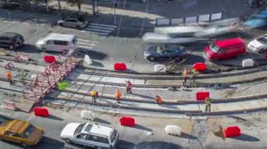 Onarım street timelapse üzerinde çalışır. Bir şehir sokak üzerinde yeni tramvay rayların döşenmesi. Yeni modern demiryolu rayları tramvaylar için montajı. Hava üstten görünüm. Tramvay parça kavşak üzerinde yeniden inşası