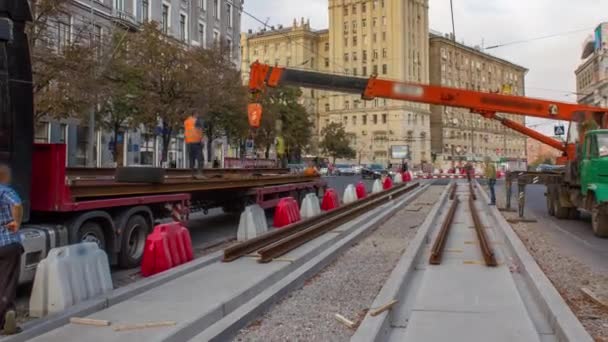 Orangefarbener Bauteleskop Mobilkran Entlädt Straßenbahnschienen Aus Dem Lkw Zeitraffer Industriearbeiter — Stockvideo