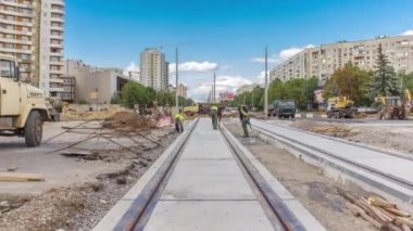 İşçiler tramvaylar için modern demiryolu raylarının inşaatından sonra tren hattının temizliğini yapıyorlar. Tramvay raylarının yeniden inşasının son aşaması