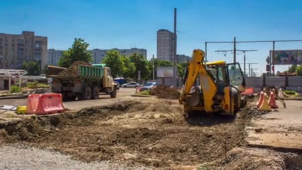 工业挖掘机在道路建筑工地挖掘地面 并将其装入卡车时刻表 大城市有轨电车轨道重建的准备工作 — 图库视频影像