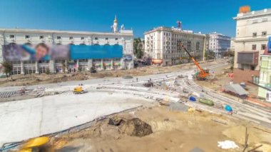 Work cranes and excavators on the construction site of a road panoramic timelapse. Crushed stone on substrate. Support activities and industrial machinery. Reconstruction of tram tracks. Aerial top