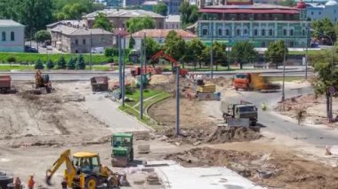Buldozerler ve ekskavatör bir yol timelapse inşaat üzerinde çalışır. Ezilmiş taş substrat üzerine. Destek faaliyetleri ve yol yapım aşamasında. Tramvay yeniden inşası izler. Hava üst görünümden