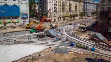 Concrete works for road intersection construction site with many workers in uniform and mixer machine timelapse. Reconstruction of tram tracks