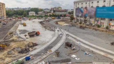 Bir yol zaman ayarının şantiyesinde çalışan kamyonlar ve mikserler. Alt tabakada ezilmiş taş. Destek faaliyetleri ve endüstriyel makineler. Tramvay raylarının yeniden inşası. Yukarıdan hava üstü görünümü