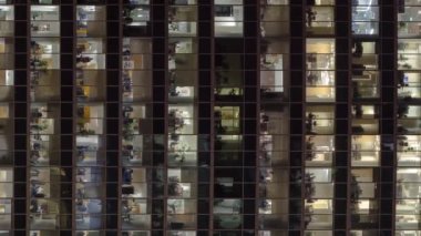 Gökdelenler Uluslararası İş Merkezi 'nin parıldayan ofis pencerelerine yakından bakın. Büyük bir şehirde, gece vakti tepeden. Portre kipinde sosyal medya için dikey ekran videosu