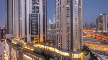 Dubai şehir merkezindeki en uzun gökdelenler, alışveriş merkezinin hava sahasının yakınındaki bulvar caddesinde gece gündüz geçiş zamanları. Gün doğmadan önce çatı bahçeleri olan yürüyüş alanı
