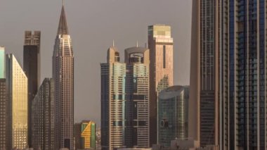 Sheikh Zayed Yolu etrafındaki yüksek binalar ve Dubai, BAE 'deki DIFC bölgesi zaman çizelgesi. Gündoğumunda cam yüzeyden yansıyan güneşli Uluslararası Finans Merkezi gökdelenleri