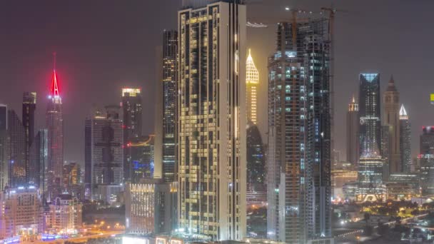 アラブ首長国連邦のドバイでの一晩中のタイムラプスの間 シェイク ザイド ロードとDifc地区航空機の周りの高層ビルの行 国際金融センターの高層ビルのライトがオフになって — ストック動画