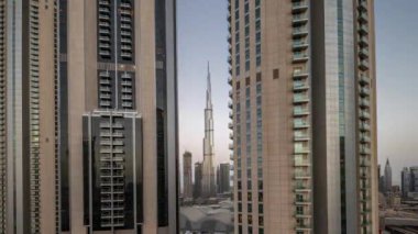 Dubai şehir merkezindeki en uzun gökdelenler, alışveriş merkezinin hava sahasının yakınındaki bulvar caddesinde gece gündüz geçiş zamanları. Gün doğarken çatısı bahçeli yürüyüş alanı