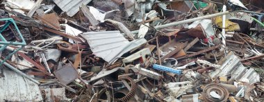 Panoramic view of pile of scrap rusty metal waste on recycling yard. Disposal and secondary metal recycling.