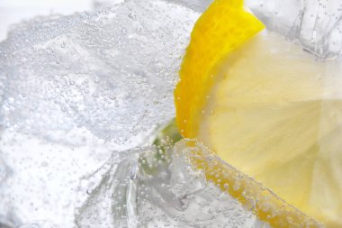 Limonlu ve buzlu suyu cam kaplamalı, seçici odaklı, soyut arkaplan.