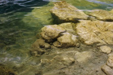 Altında şeffaf su ve büyük granit taşlar olan soyut doğa arka planı.