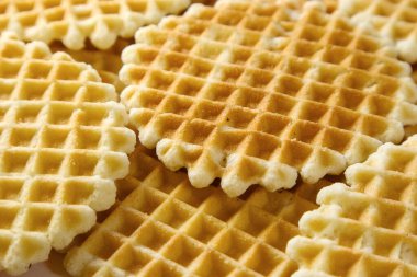 Arka plan olarak yuvarlak Belçika waffleları yığını, seçici odaklanma. İnce altın waffle kurabiyeleri.