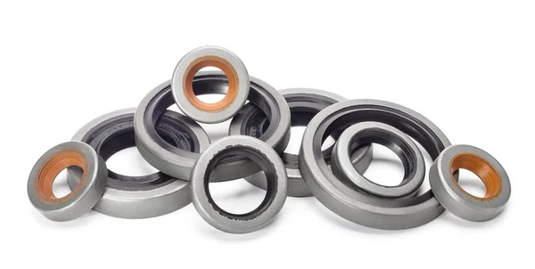 Rubber reinforced oil seals for shafts and for car motor engines, isolated on white background. Cuffs for prevent liquid leak. Car parts.