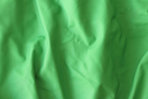 The texture of the green crumpled rubber balloon. Crumpled rubber of a children's balloon.