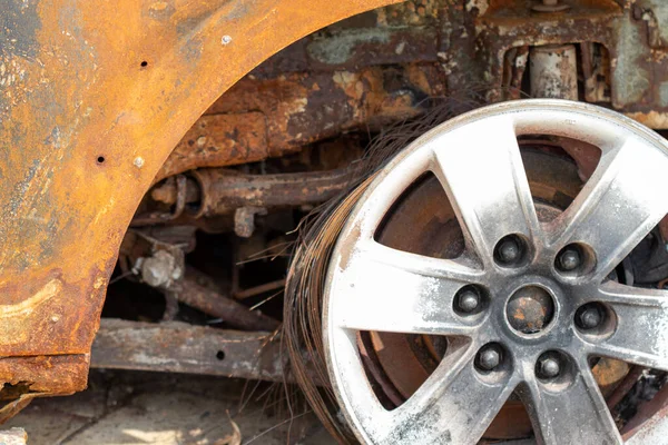 Burnt rusty car. A civilian car with people in Ukraine was shot and burned by the Russian military.