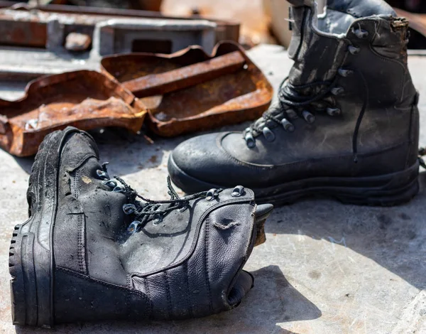 Old army boots - berets on a metal background.
